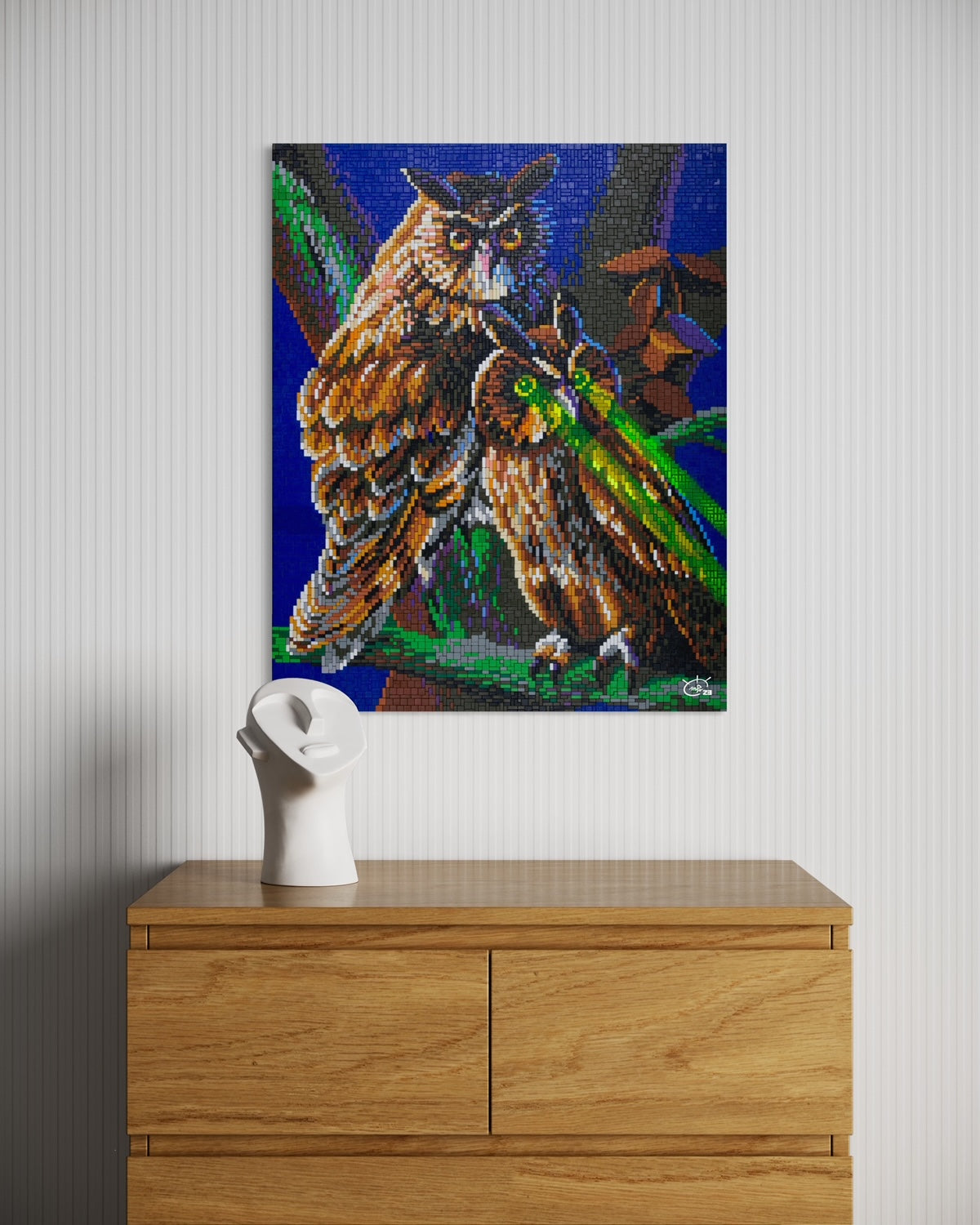 A vibrant pixel art canvas of two owls, with one owl's glowing laser eyes, hanging on a modern white wall. The scene brings a touch of nature and technology to the minimalist decor.