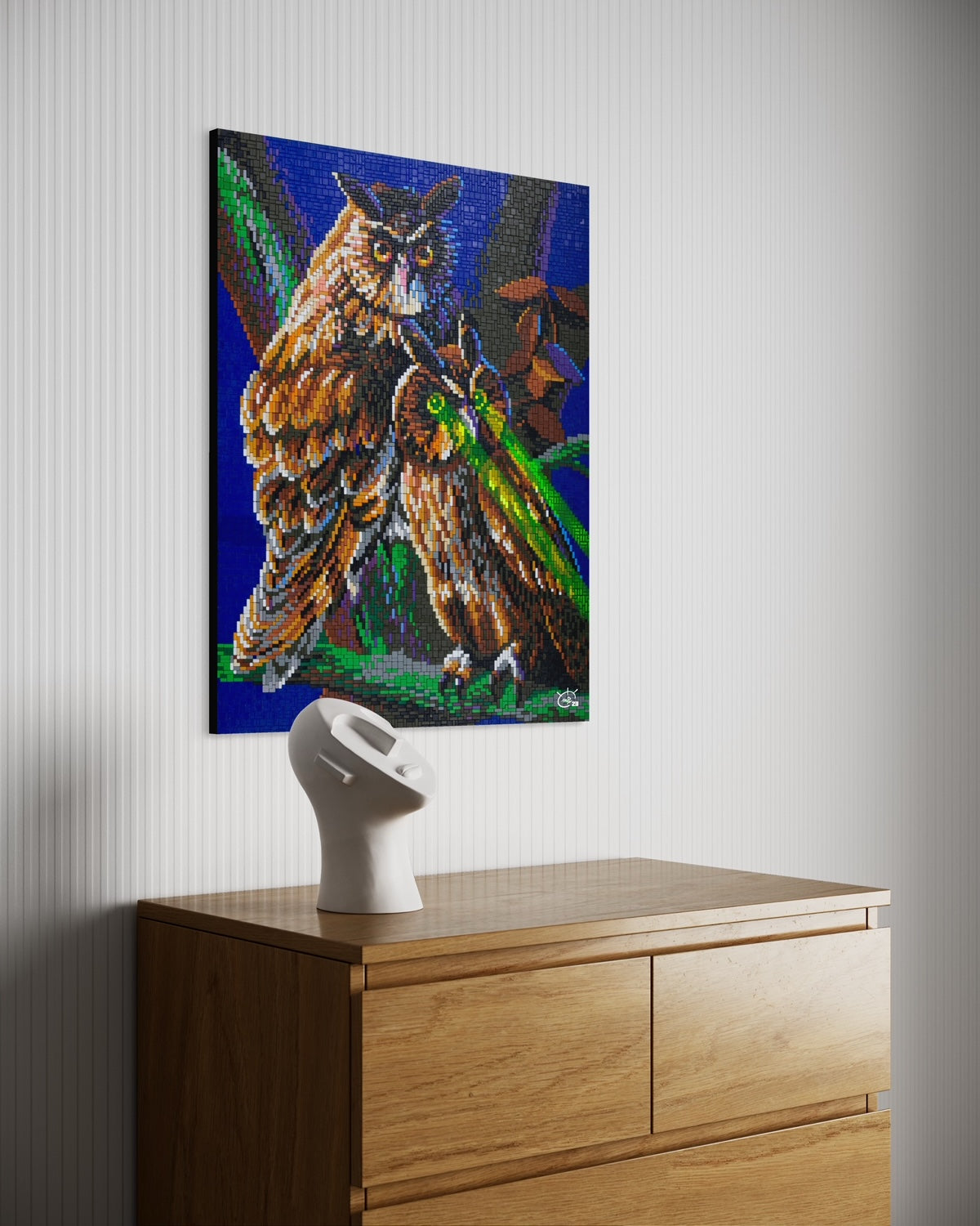 A pixel art canvas featuring two owls, one with bright green laser eyes. The artwork is displayed in a stylish modern room, complementing the clean decor with its vivid colors and unique theme.